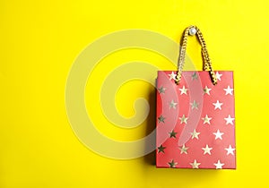 Red shopping paper bag with star pattern on background, space for text