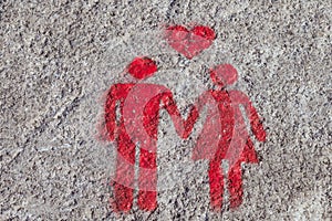 A red sign is drawn on the sidewalk of Porto: the heart, man and woman hold hands. A sign of free space for couples