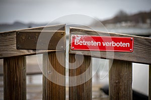 On red sign at a gate is written in german: Betreten verboten