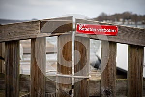 On red sign at a gate is written in german: Betreten verboten