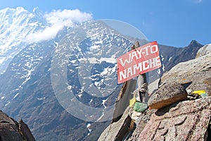 Red sign with text `way to Namche` in Himalayas