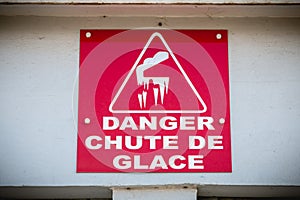 Red sign where it is written in French - danger ice fall