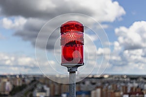 Red signal beacon. Signal lights on the roof of a multi-storey building against the backdrop of city buildings. Air transport