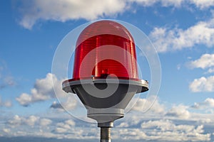 Red signal lamp against the blue sky