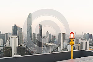 Red signal lamp or aircraft warning light on highrise building or condominium rooftop. Architecture security, safety concept