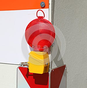 red signal lamp in the corner of the road construction site during the work of the workers