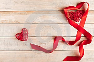 Red silk ribbon in shape of a heart on a wooden background. Valentine& x27;s day concept. Place for text.