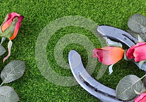Red silk roses, a horseshoe and artificial green grass for the running of the thoroughbred race called the Kentucky Derby. photo