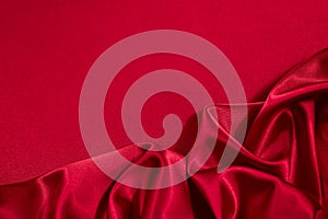 Red silk satin background. Copy space for text or product. Wavy soft folds on shiny fabric.