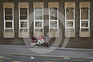 Red silver metallic motorcycle parked on a road in Paris, France