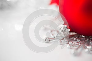 Red and silver xmas ornaments on bright holiday background.