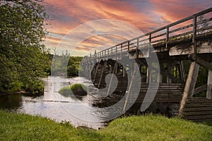 Red Skies over a Wooden road Bridge on the road Carrbridge, Highlands, Scotland,UK