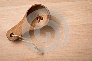 Red skinned rice in portion spoon on wooden background as symbol for hunger, famine, poverty or diet and healthy nutrition