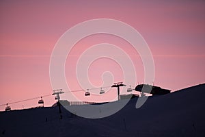 Red sky during the evening in skiing resort. Winter holiday in the mountains, beautiful view, snow and skiing.