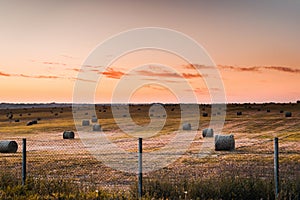 Red sky over fields with haystacks in the countryside.