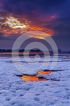 Red sky sunset over snowy Poole beach