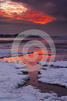 Red sky sunset over snowy Poole beach