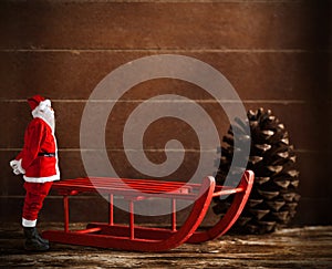 Red sled with pine cone and Santa Claus