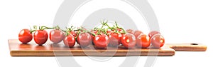 Red small cherry tomatoes on a wooden surface and white background