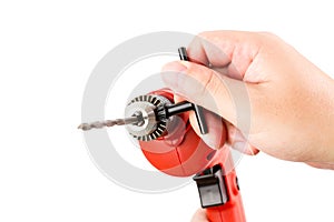 Red Small Electric drill machine with drill bit and hand.