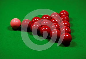 Red snooker balls arranged for a new game on a green table.