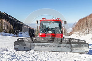 Red snowcat on ski slopes