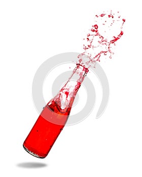 Red soda in bottle splashing