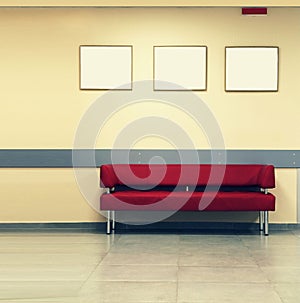 Style minimalism. Red Sofa, interior design, office. Empty waiting room with a modern red sofa in front of the door and three empt