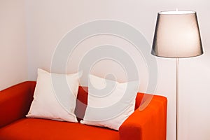 Red sofa with pillow and light lamp