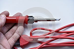 Red soldering iron on a white background. A tool for repairing electronics