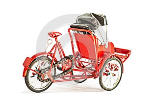 Red souvenir tricycle on white background