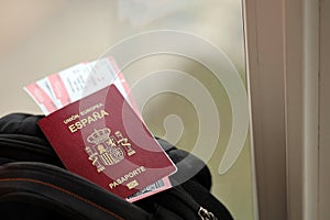 Red Spanish passport of European Union with airline tickets on touristic backpack photo