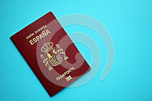 Red Spanish passport of European Union on blue background close up