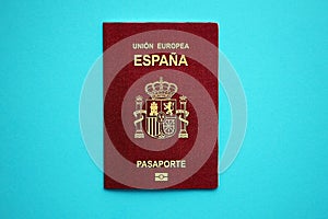 Red Spanish passport of European Union on blue background close up photo