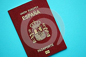 Red Spanish passport of European Union on blue background close up photo