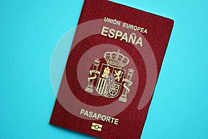 Red Spanish passport of European Union on blue background close up photo