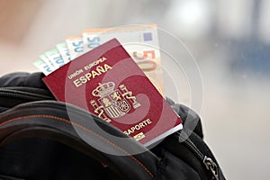 Red Spanish passport of European Union with money and airline tickets on touristic backpack photo