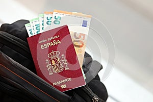 Red Spanish passport of European Union with money and airline tickets on touristic backpack photo