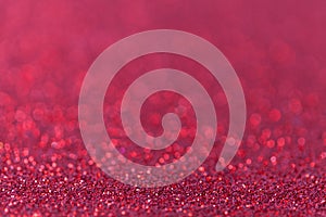 Red sparkling background from small sequins, closeup. Brilliant backdrop