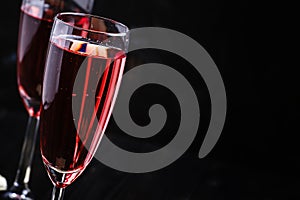 Red sparkling wine, black background, selective focus