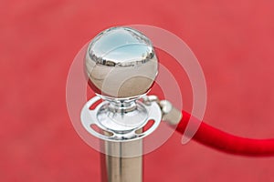 Red sphere on stand in red setting, reflective surface, diffuse artificial lighting, interior space hinted photo