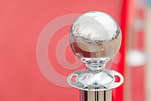 Red sphere on stand in red setting, reflective surface, diffuse artificial lighting, interior space hinted photo