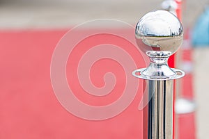 Red sphere on stand in red setting, reflective surface, diffuse artificial lighting, interior space hinted photo