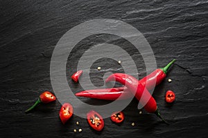 Red spicy chili peppers over dark slate. Food background.