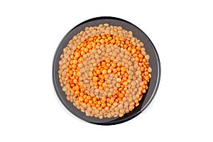 Red split lentil in black bowl isolated on white background