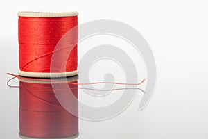 Red spool of thread on a table