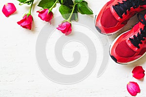 Red sport shoes and red roses on white wooden background, Valen