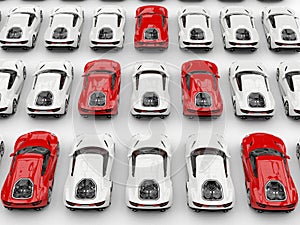 Red sports cars in formation amongst white cars