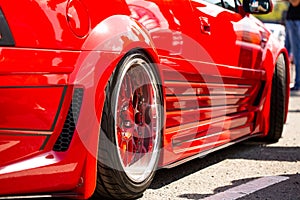 Red sports tuned car rear view of the wheel, close-up .