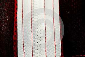 Red sportswear closeup top view. white zip line on the wrong side. breathable knitwear. clothing details macro